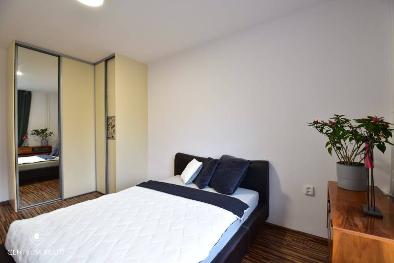 Bedroom in a 2-room apartment with a bed, wardrobe, and wooden dresser.