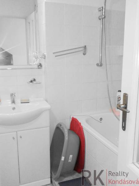 Bathroom in a 2-room apartment with a bathtub and a sink, white tiles.