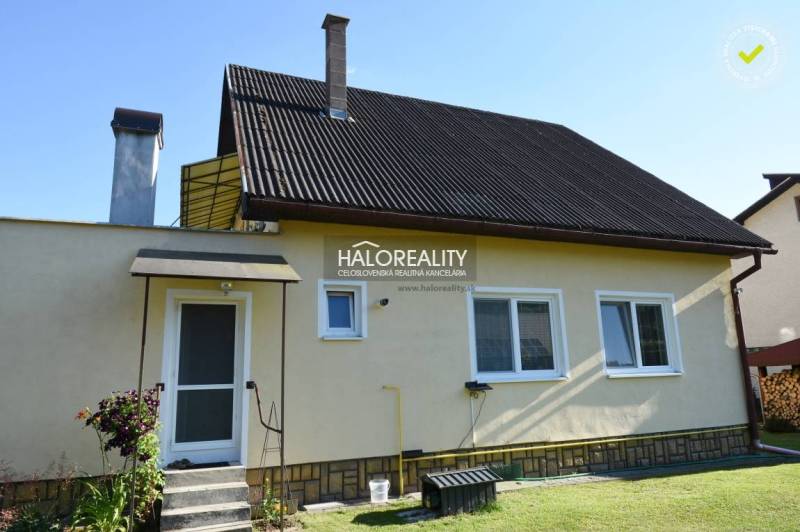 A family house in Župkov with a metal roof, a garden, and two chimneys.
