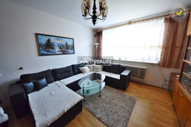 Living room in a family house with a large sofa and a painting on the wall.
