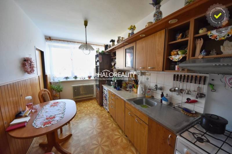 A kitchen in a family house with a wooden cabinet, table, and decorative placemats.