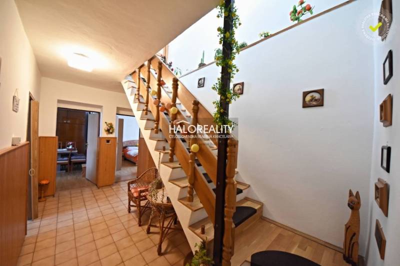 Interior of a family house with wooden stairs and entrances to multiple rooms.