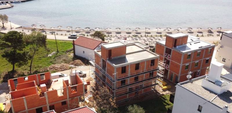 Construction work near the beach in the town of Vir, with unfinished buildings close to the shore.
