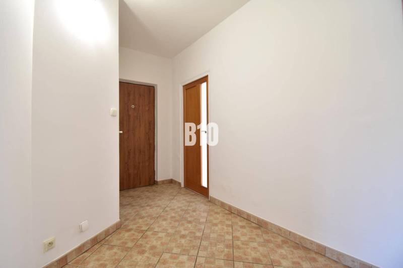 A hallway with ceramic tiles and white walls in a 4-room apartment.
