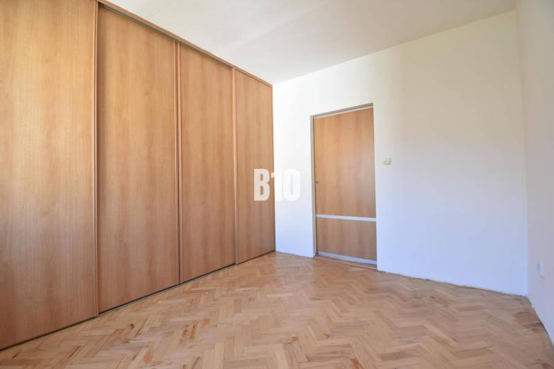 A room with a built-in wardrobe and wooden floor in a 4-room apartment.