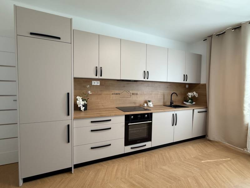 A kitchen in a 3-room apartment with a complete set of cabinets, a wooden countertop, and decorations.