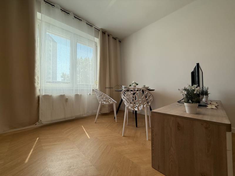 Dining area with a table, chairs, and a cabinet in a 3-room apartment.