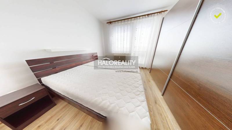 A bedroom in a three-room apartment with a built-in wardrobe and a large window.