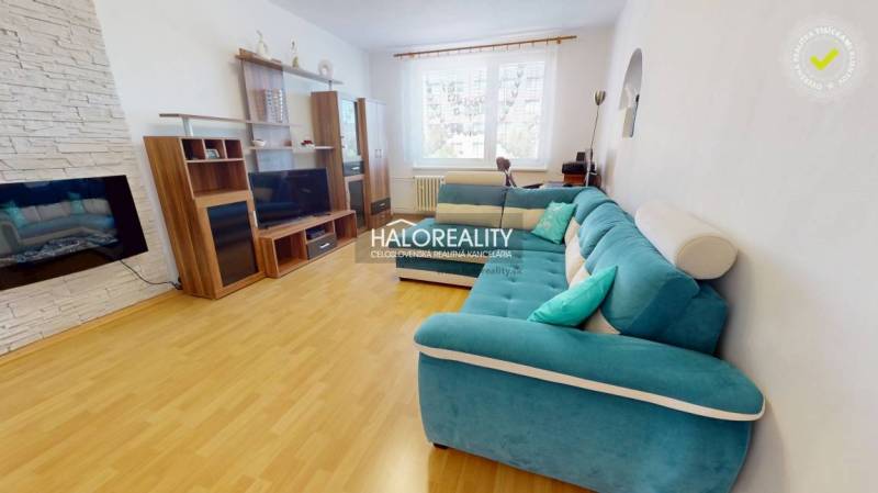 Living room in a 3-room apartment with wooden flooring and a turquoise sofa.