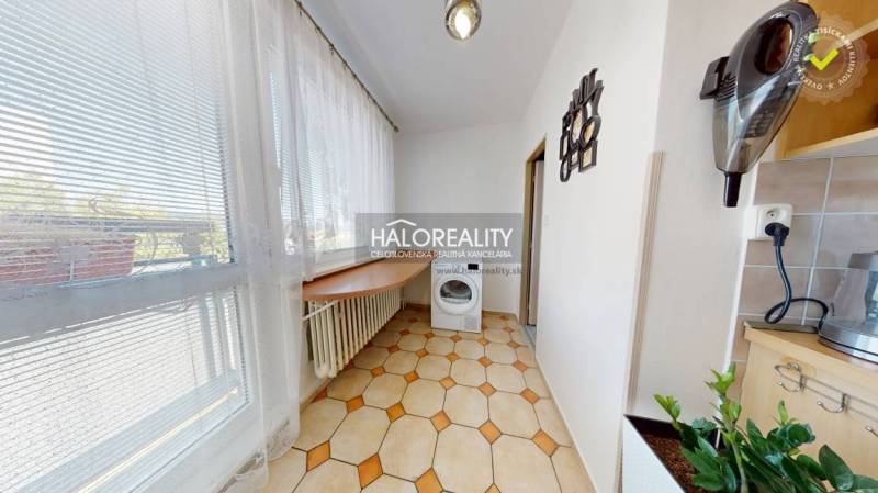Bright loggia with a washing machine and a view in a 3-room apartment.