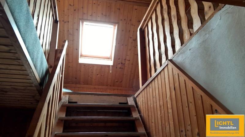 A staircase with wooden paneling and a skylight in a family house.