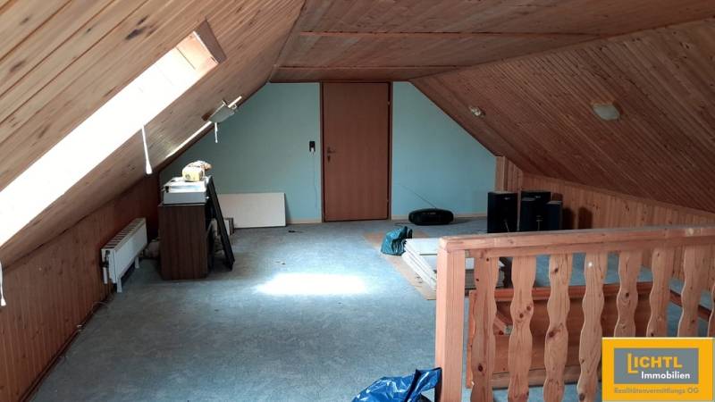 The attic of a family house with wooden paneling and skylights.