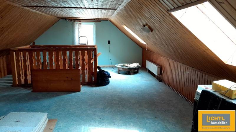 An attic room with skylights and wooden paneling in a family house.
