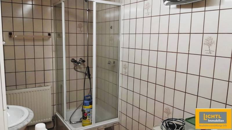 Bathroom with tiles and a shower in a family house.