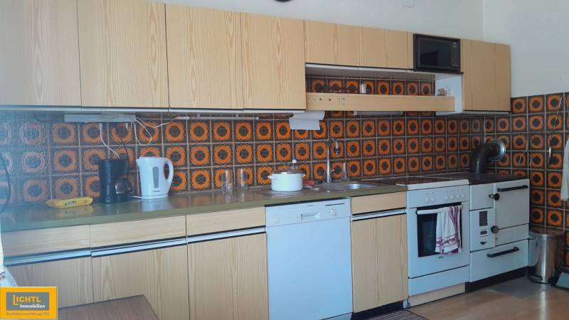 A kitchen in a family house with retro tiles and built-in appliances.