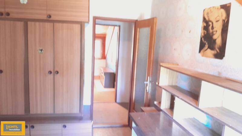 A room in a family house with built-in wardrobes, shelves, and a retro picture.