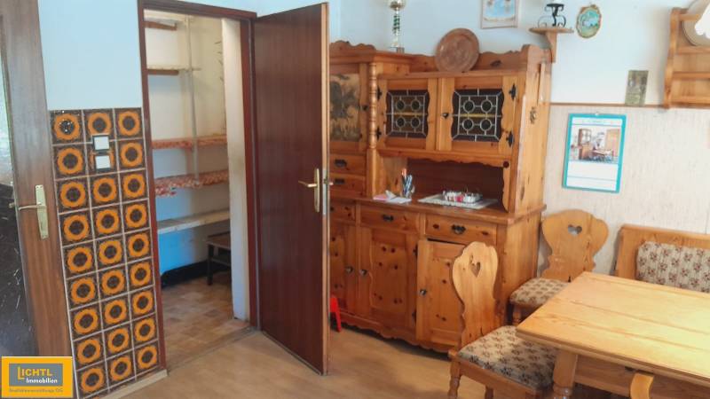 Wooden furniture in the interior of a family house with ornamental wall cladding.
