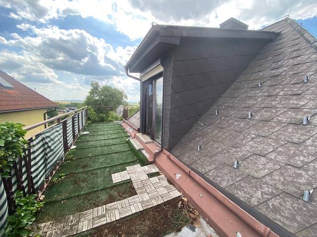 Attic terrace of a family house in Hundsheim with a view and a lawn area.