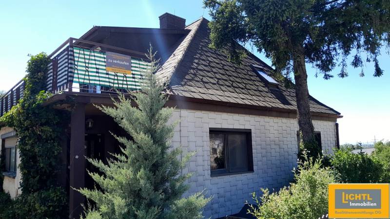 Family house in Hundsheim with a sloped roof and a terrace for sale.