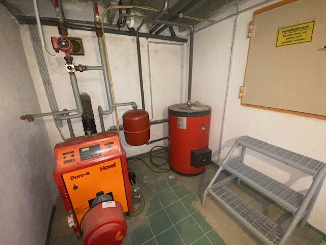 Boiler room in a family house with a boiler and a storage tank.
