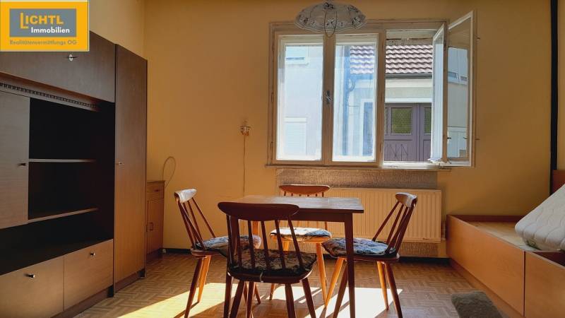 A room with a table and chairs lit by the sun, Apartment construction.