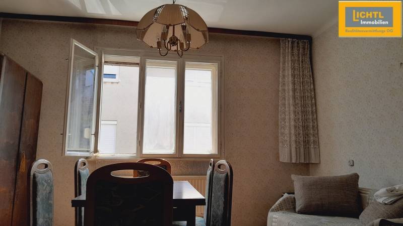 Dining room with a table, chairs, sofa, window, and chandelier, Apartment construction.