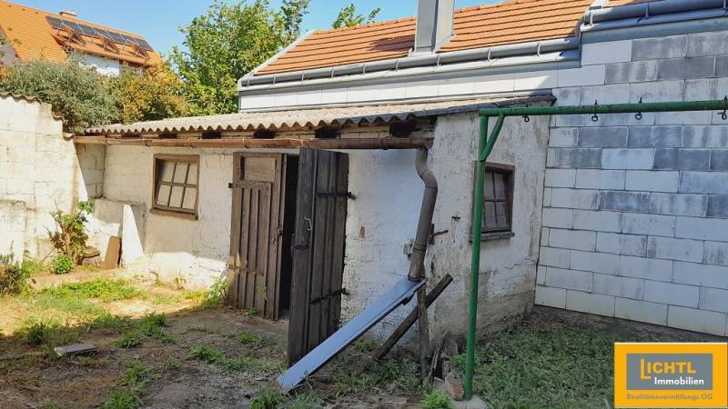An older farm building in the yard during the construction of apartments in Jois.