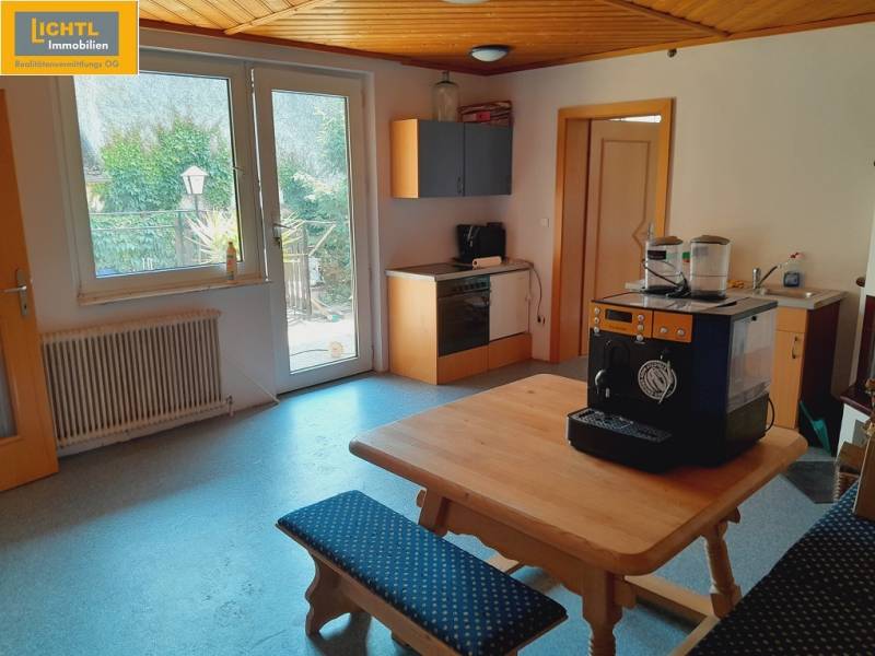 Interior of a gastro space with a wooden kitchen unit and a coffee machine on the table.