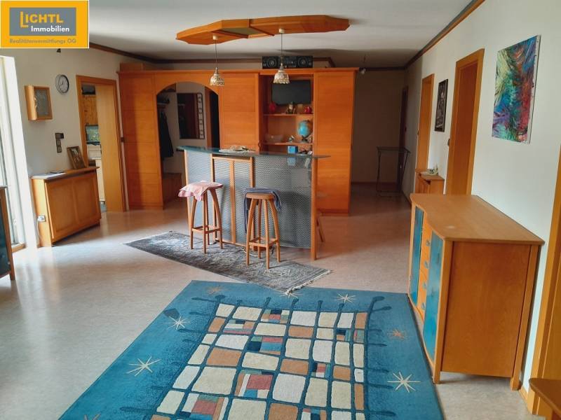 Interior of a gastro space with a table, chairs, and a vibrant colored carpet.