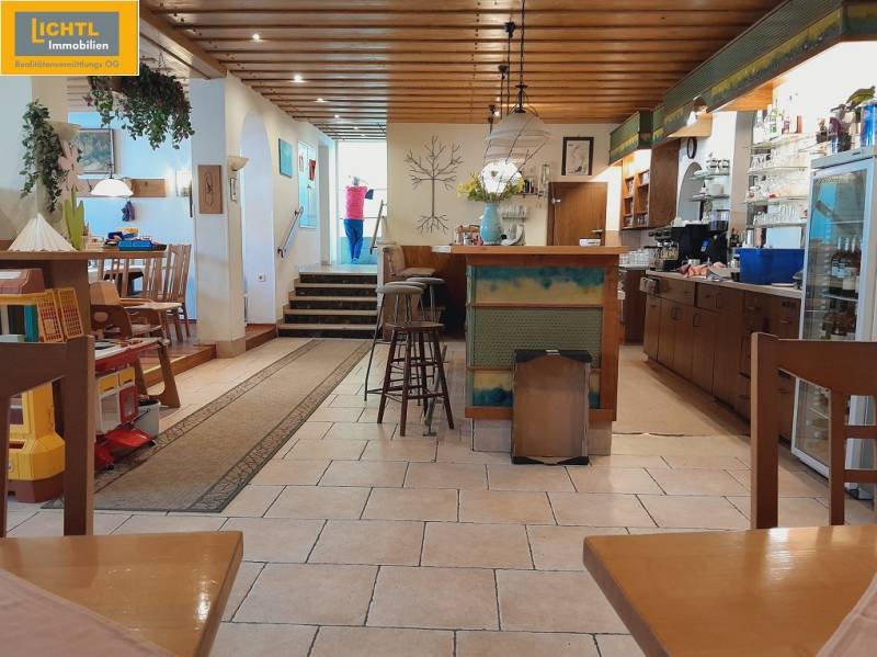 Gastro premises with a wooden ceiling, bar, and children's corner.