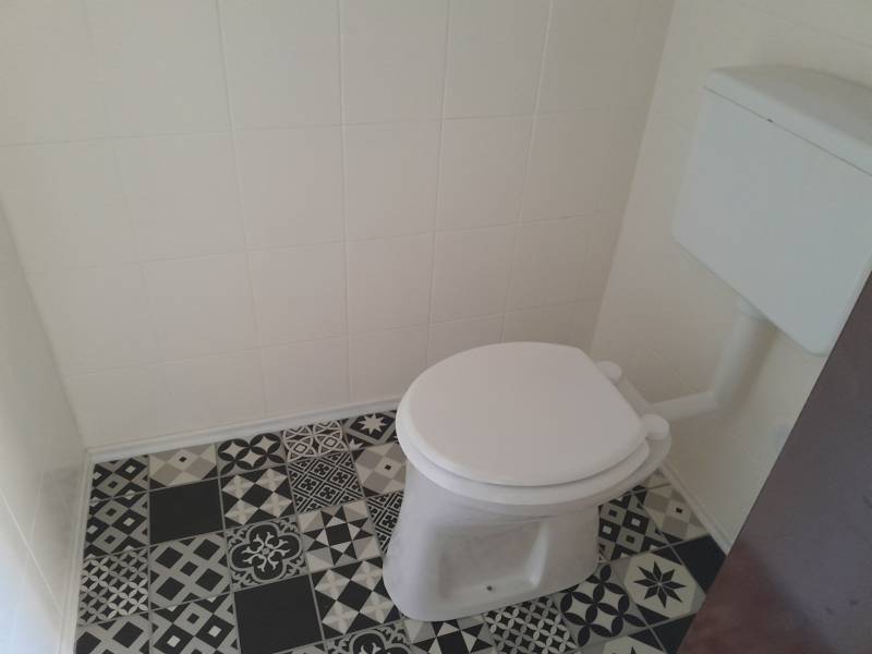 A restroom with a ceramic floor in commercial premises.