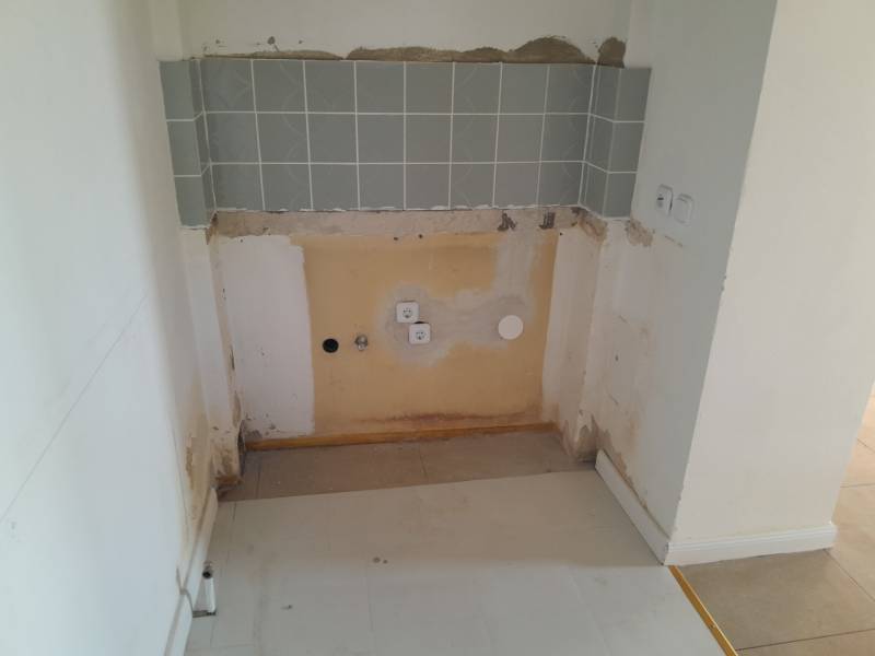 Space for kitchen appliance with tiling in commercial premises.
