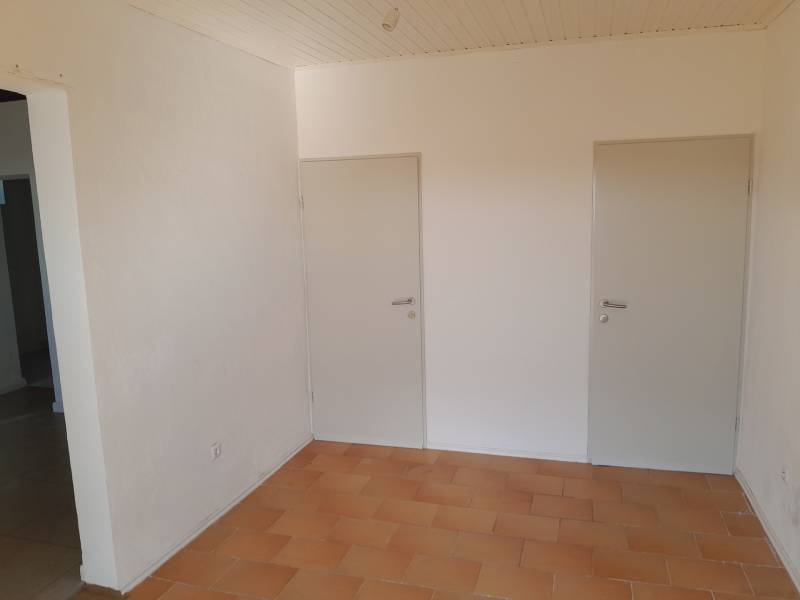 Interior of commercial premises with two white doors and tiles.