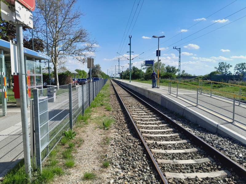 Train station in St. Andrä am Zicksee with tracks and a passenger on the platform.