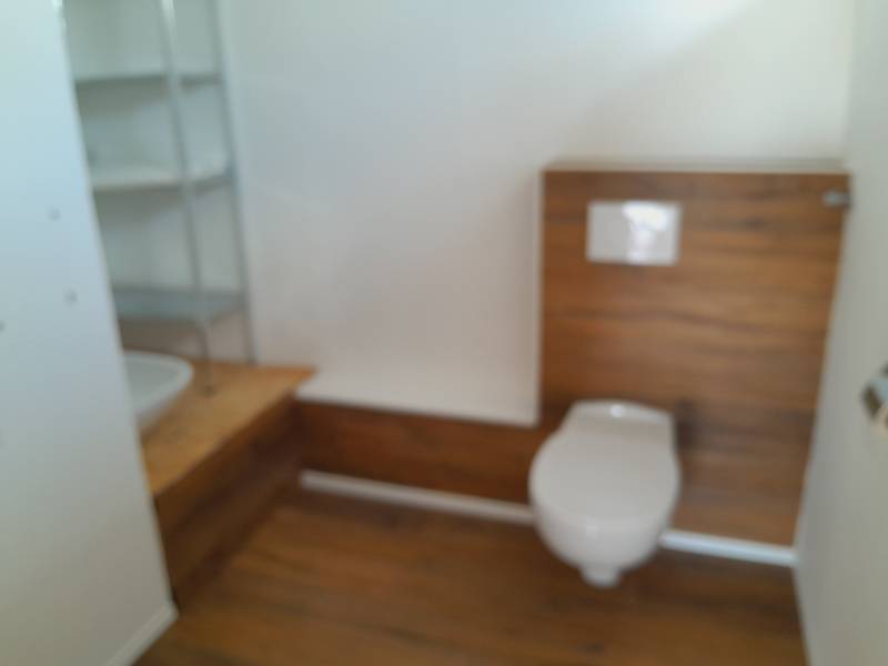 Bathroom with toilet and wooden paneling in commercial premises.