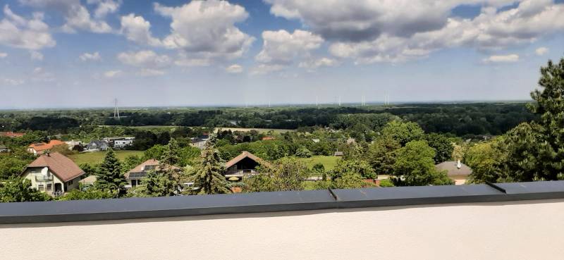 View from the villa in Hainburg an der Donau of the landscape with wind turbines and houses.