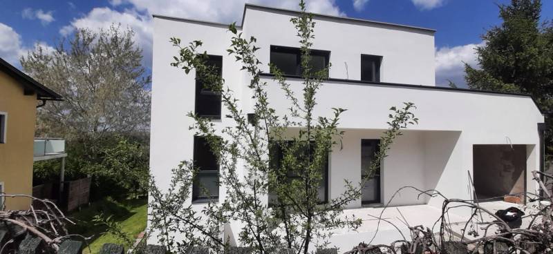 A villa in Hainburg an der Donau with a minimalist facade and surroundings full of greenery.