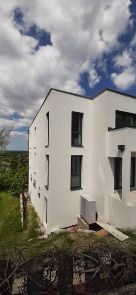 A white facade of a villa in Hainburg an der Donau with modern black windows.