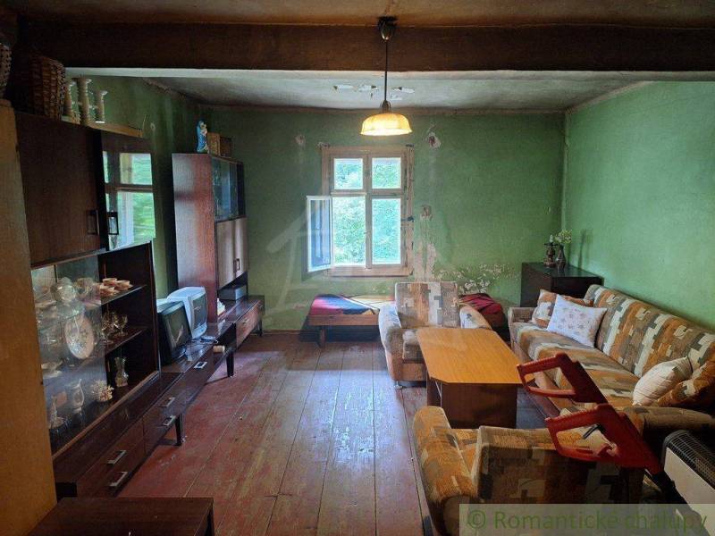 Living room in a cottage with a sofa, coffee table, and retro TV.