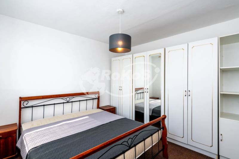 A bedroom with a wardrobe and a bed in a 2-room apartment.