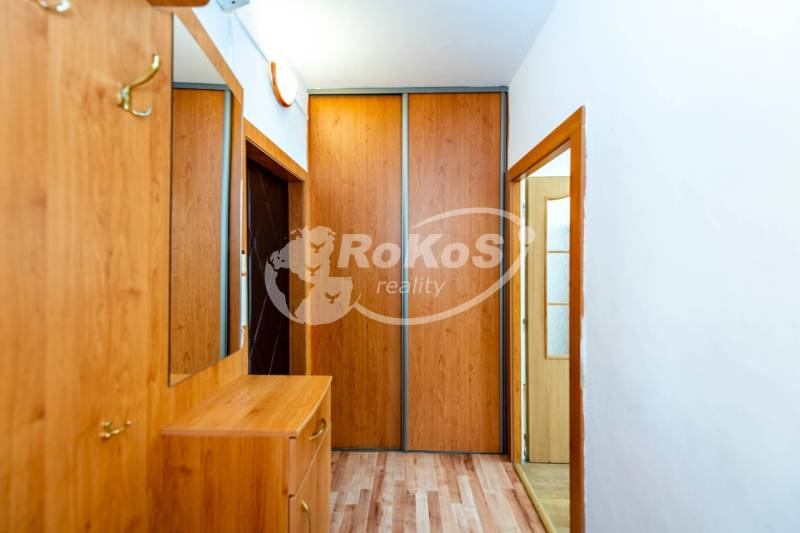 Entrance hallway with wooden furniture and a wardrobe in a 2-room apartment.