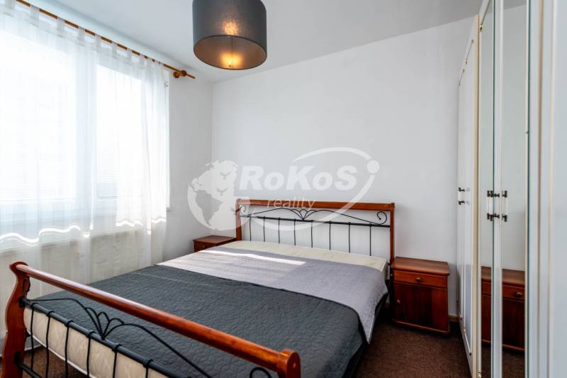 Bedroom in a 2-room apartment, comfortable bed, wardrobes, and nightstands.