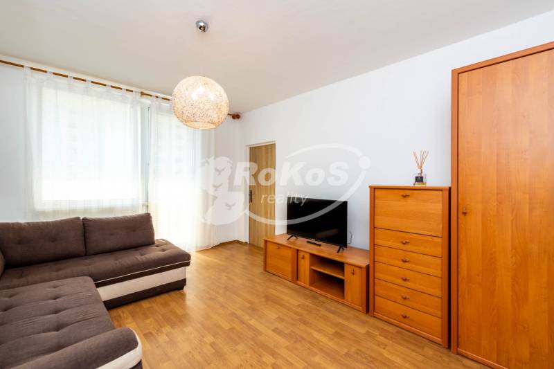 Living room in a 2-room apartment with brown furniture and a sofa, bright room.