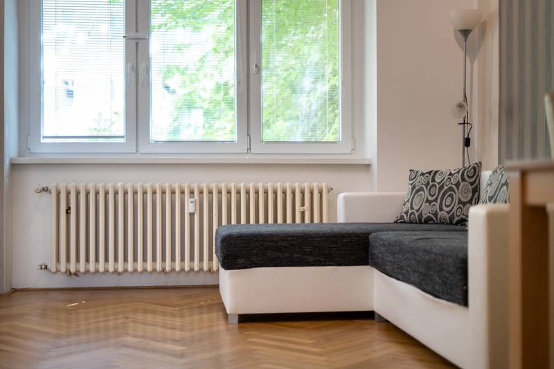Living room with a sofa bed and a heating unit in a 3-room apartment.