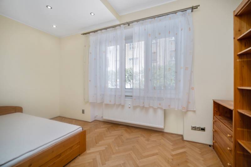 Bright bedroom with curtains and wooden furniture in a 3-room apartment.