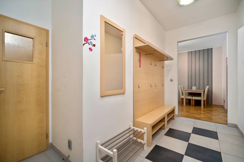 A hallway with a coat rack and a shoe cabinet in a 3-room apartment, leading to the dining room.