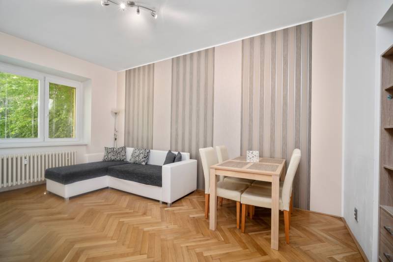 Living room with a corner sofa, table, and parquet flooring in a 3-room apartment.