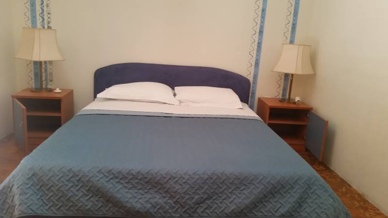 Bedroom in a family house, with a double bed and nightstands.