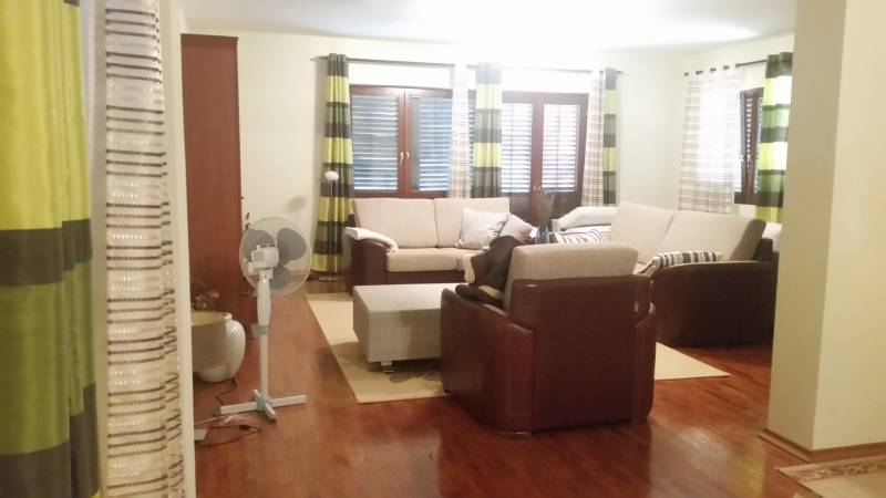 Living room in a family house with a comfortable sofa set and a fan.