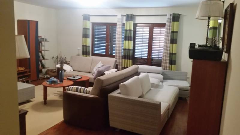 Living room with comfortable sofas, wooden furniture, and curtains in a family house.